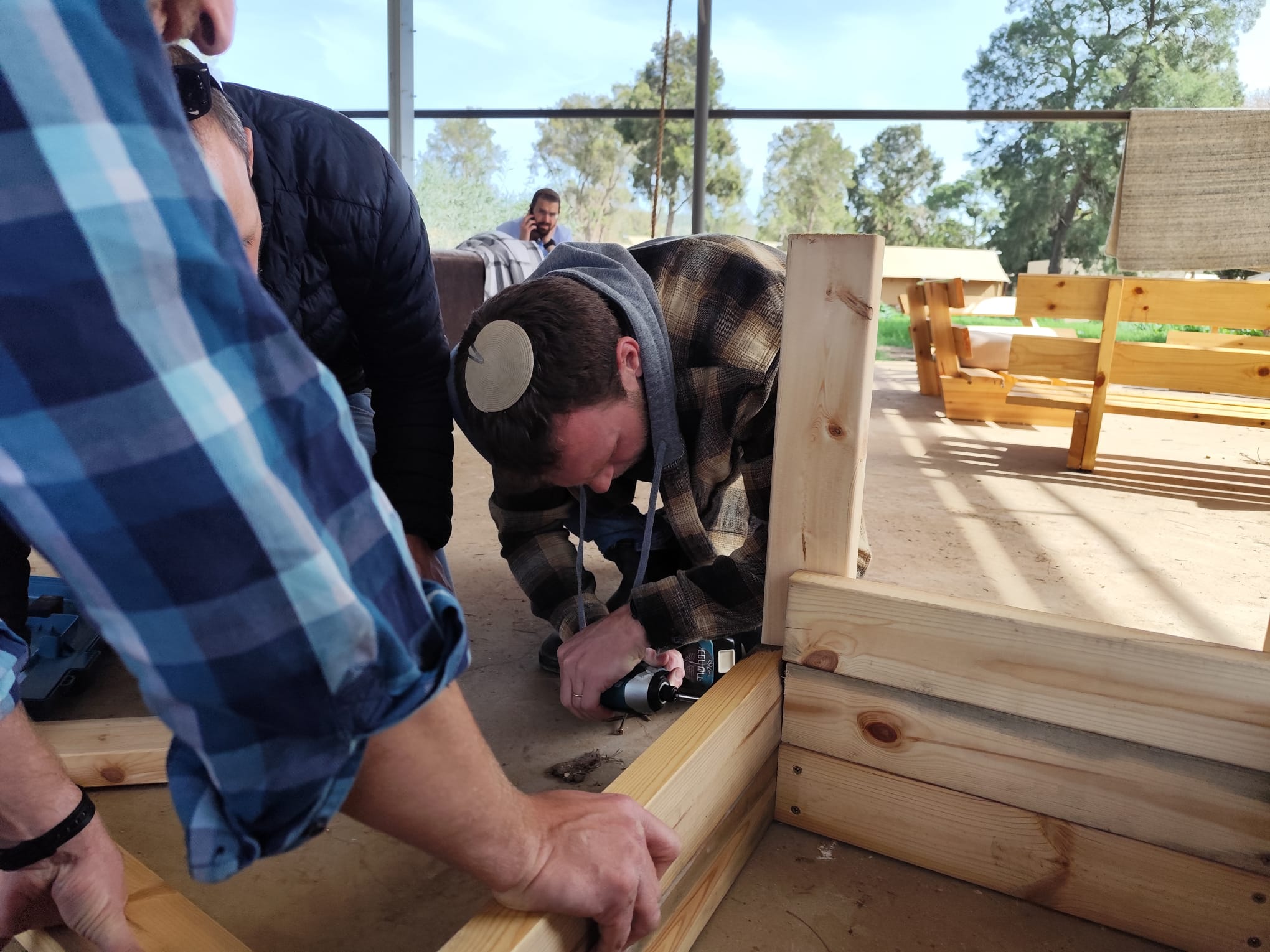 Man concentrating while drilling wood at the workshop